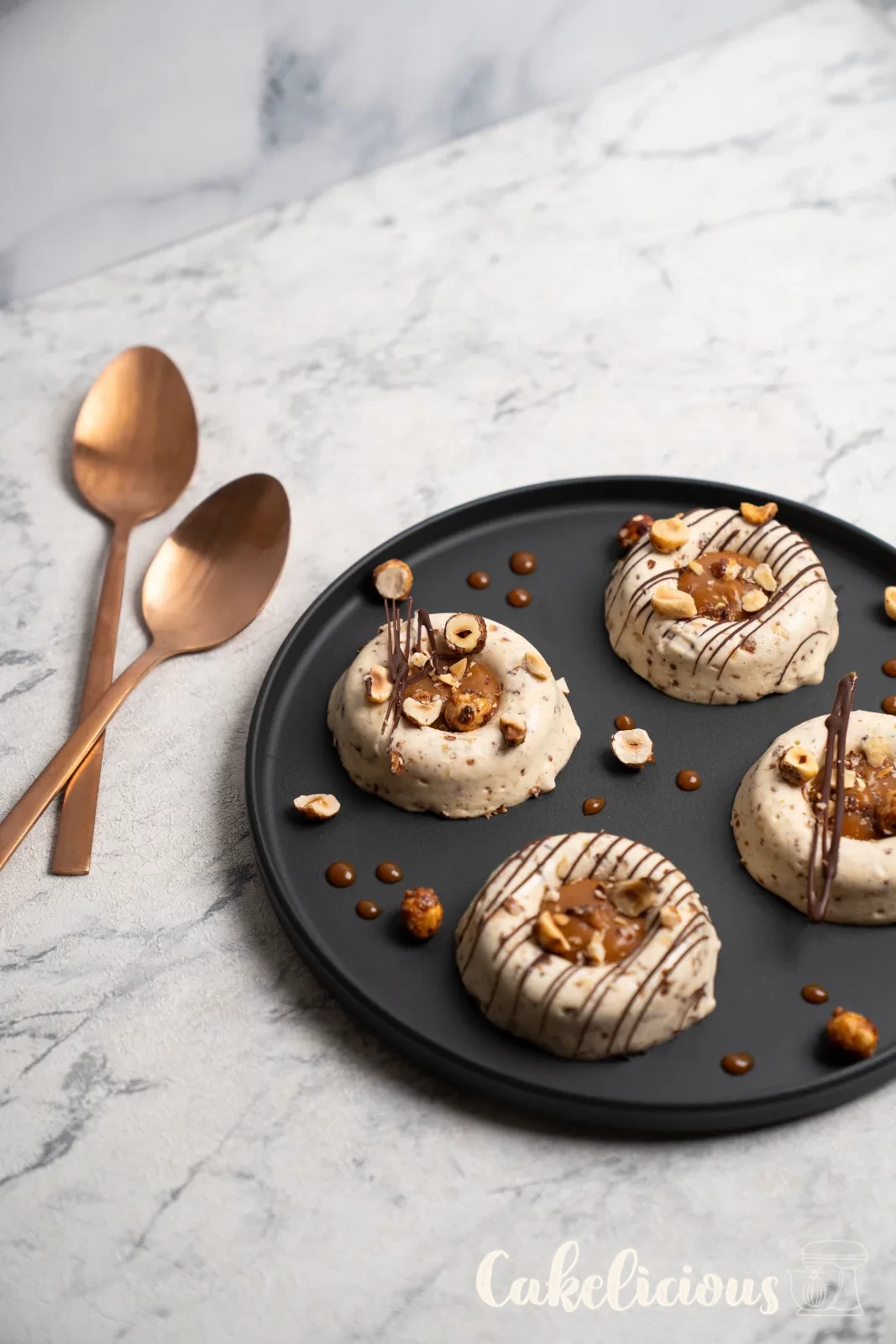 Hazelnut caramel parfaits from above, with copper spoons on a woven coaster