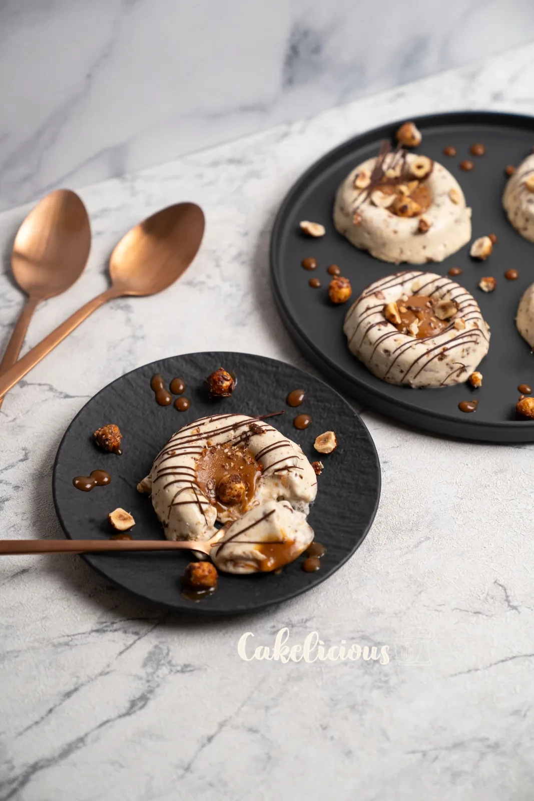 Hazelnut caramel parfaits from above, with copper spoons on a woven coaster