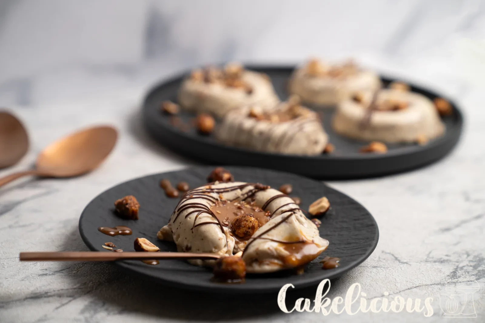Hazelnut caramel parfaits from above, with copper spoons on a woven coaster