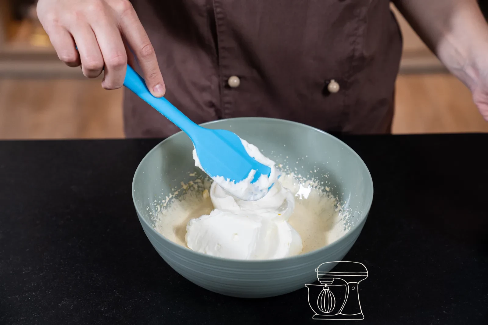 Whipped full cream being added to the egg yolk mixture with the dough scraper