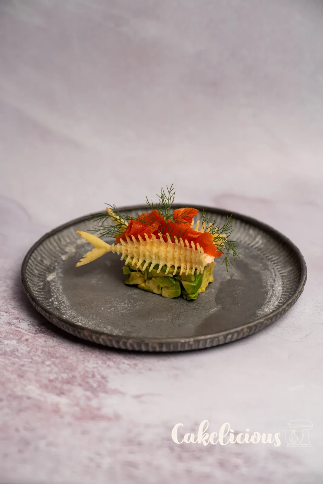 Antipasto di salmone e avocado con Hüppen a lisca di pesce e aneto su un piatto verde