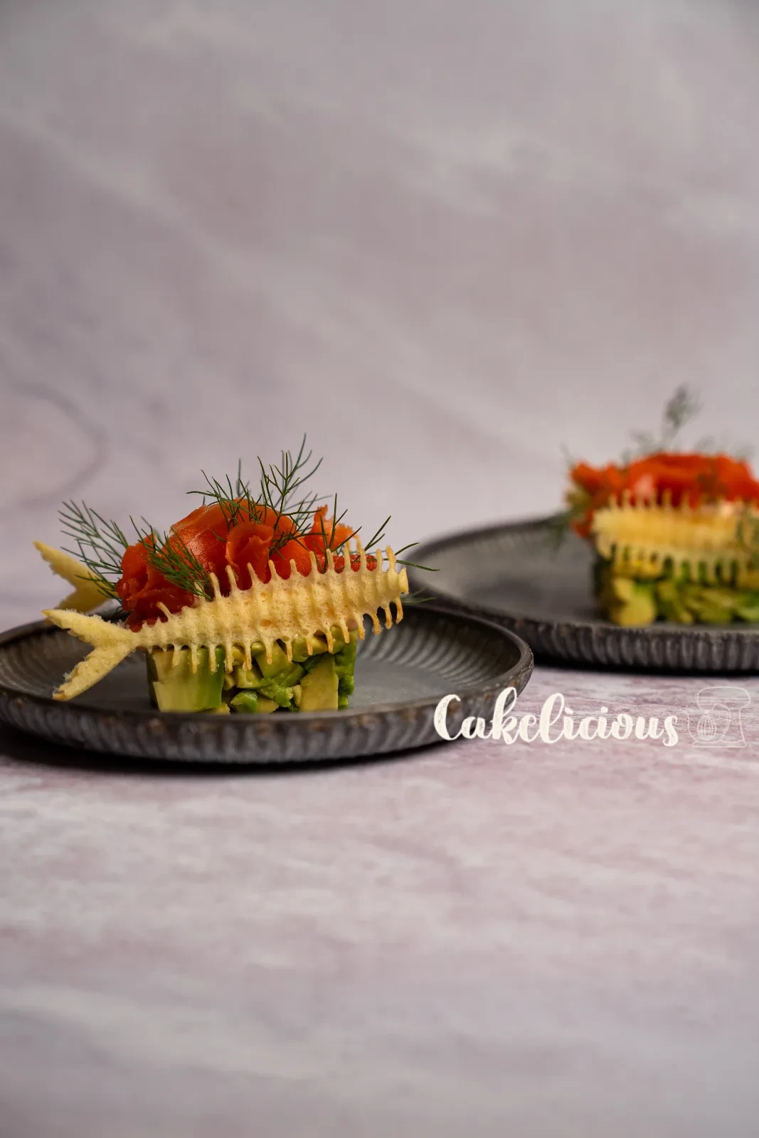 Antipasto di salmone e avocado con Hüppen a lisca di pesce e aneto su un piatto verde