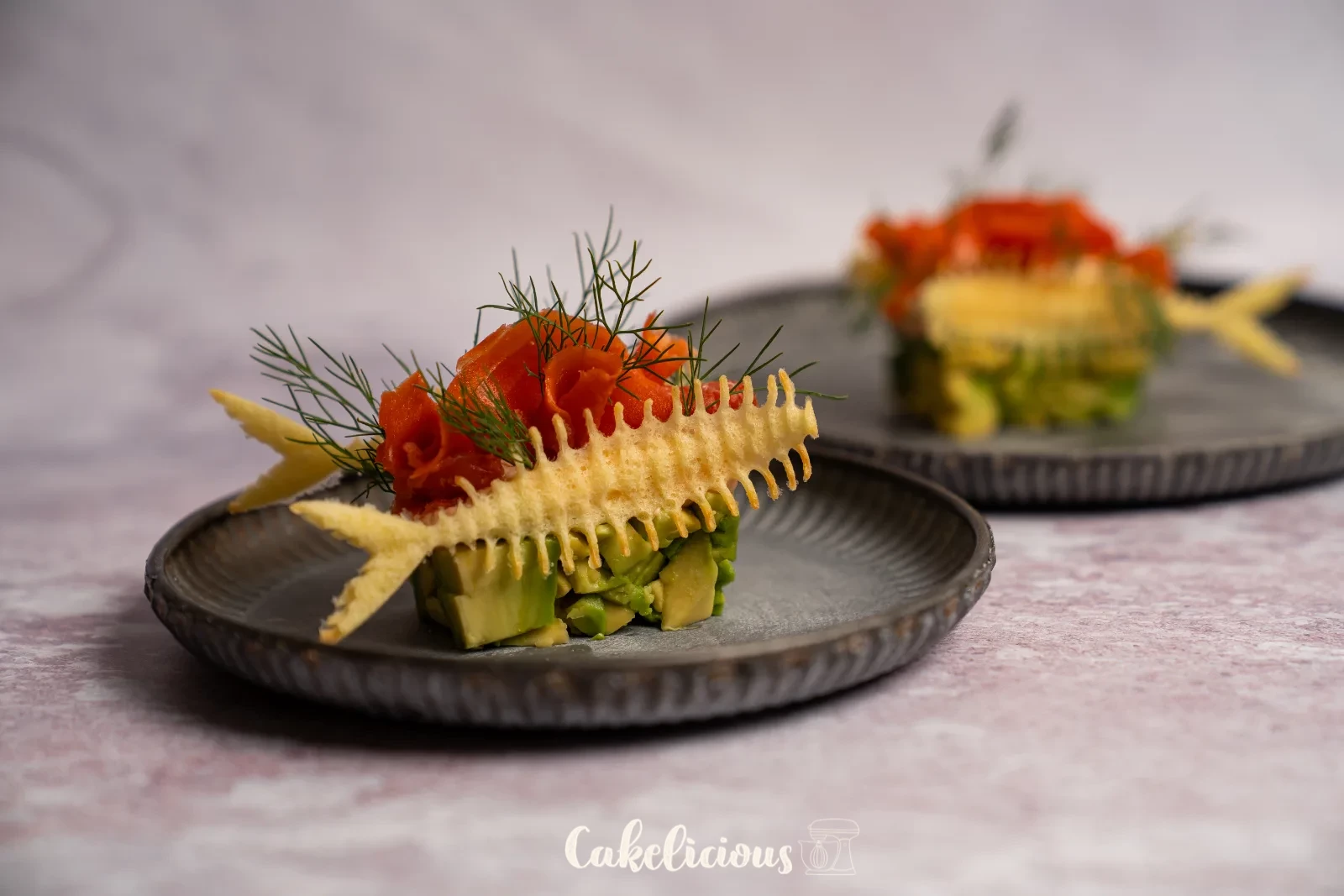Antipasto di salmone e avocado con Hüppen a lisca di pesce e aneto su un piatto verde