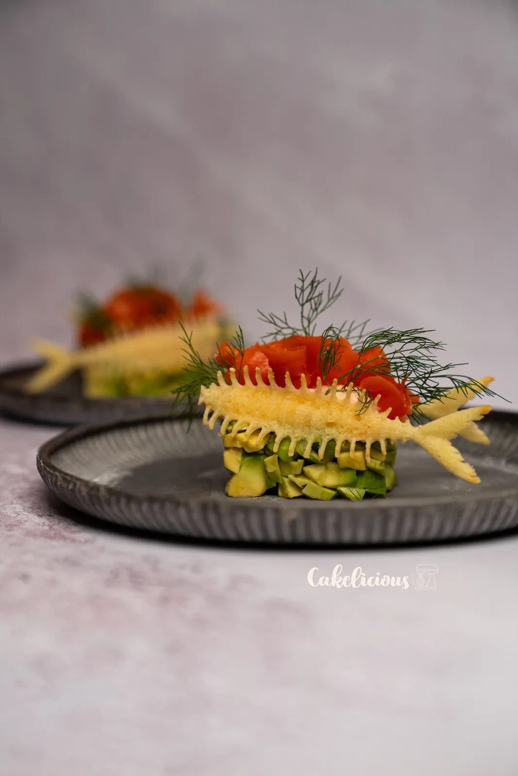 Antipasto di salmone e avocado con Hüppen a lisca di pesce e aneto su un piatto verde