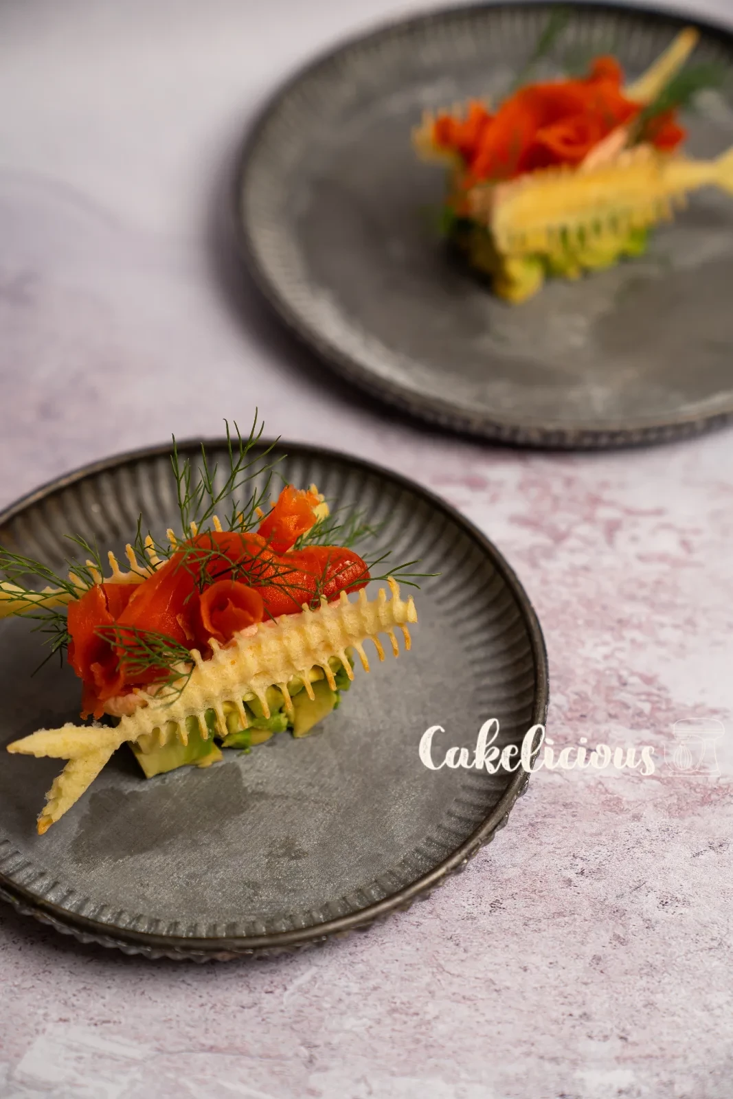 Antipasto di salmone e avocado con Hüppen a spina di pesce e aneto su un piatto verde