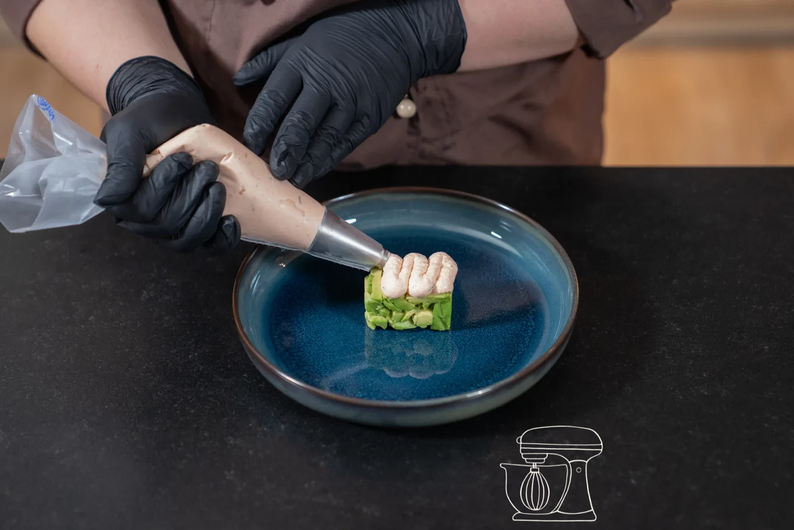 Il mousse di salmone viene dressato sull'avocado con il Sac à poche