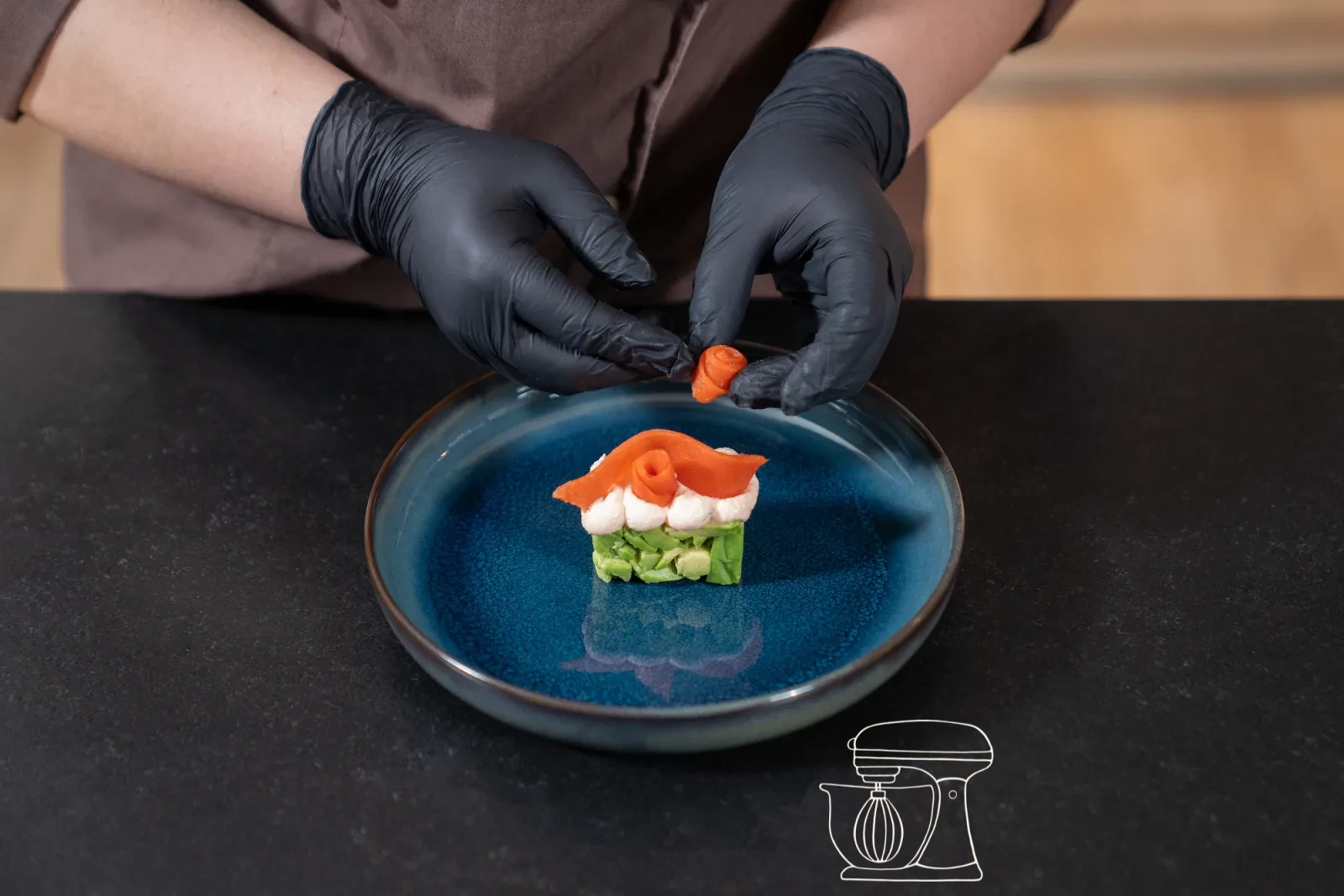 Una rosellina di salmone affumicato viene posata sul mousse