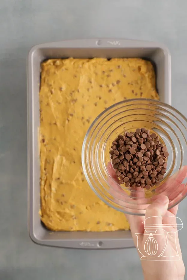 Chocolate pieces being scattered over the batter