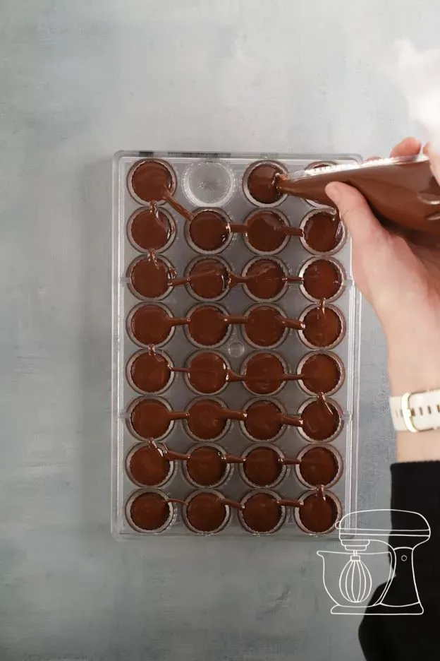 Les alvéoles du moule sont remplies de chocolat
