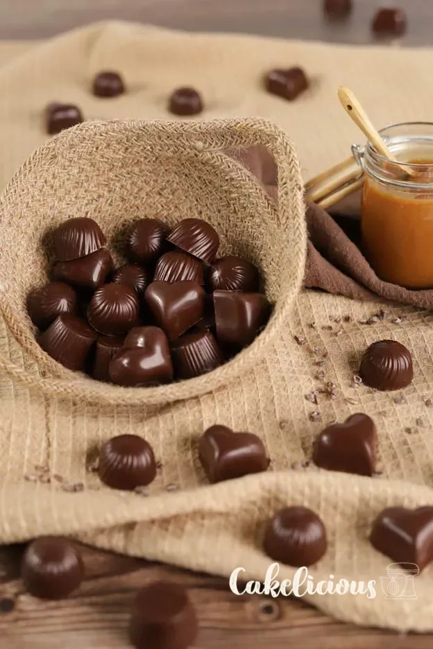 Pralines brillantes dans un panier et sur un torchon en jute