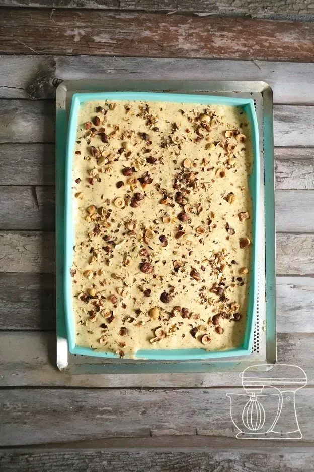 Chopped hazelnuts are spread over the sponge mixture
