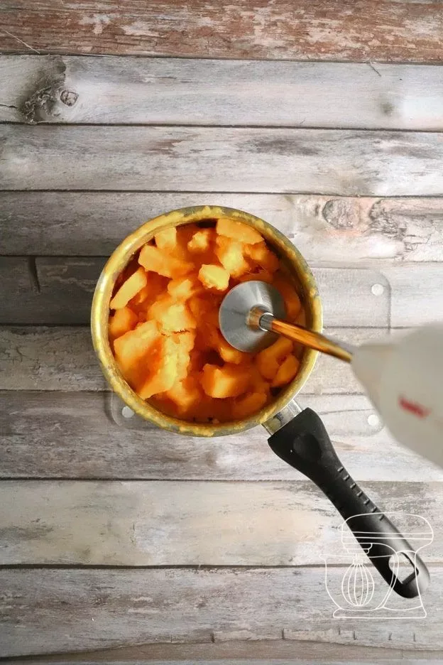 Squash being blended into purée with a hand blender