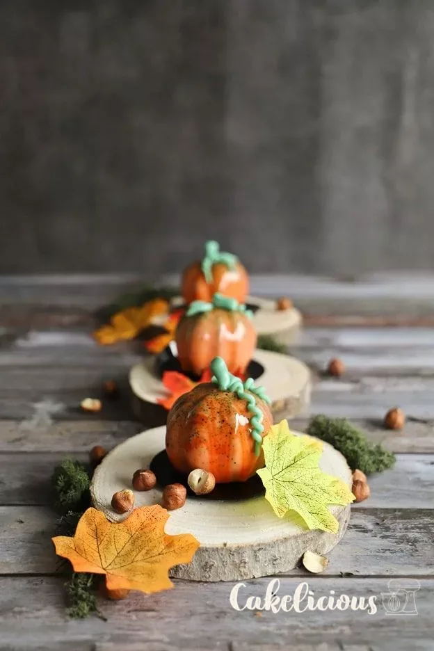 Pumpkin mousse tartlets with orange mirror glaze and stems made of Modeling chocolate