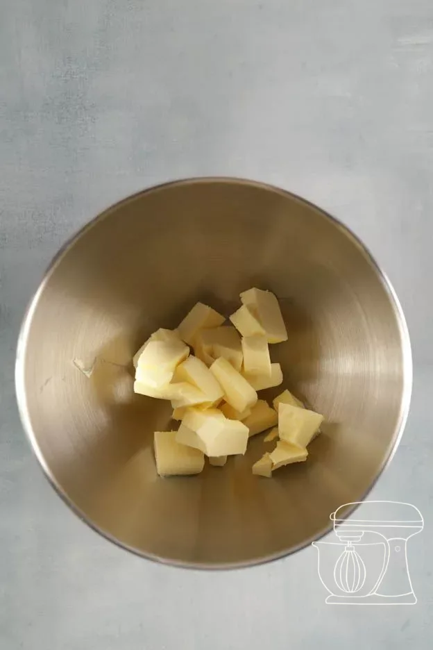 Brown icing sugar being added to the butter