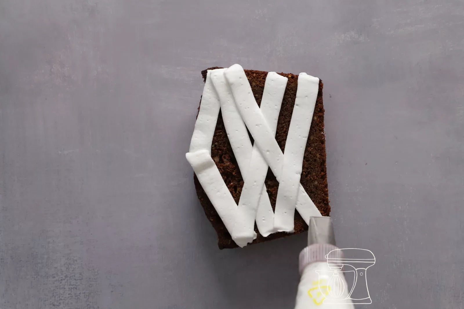 Nastri di crema incrociati su una fetta di cake