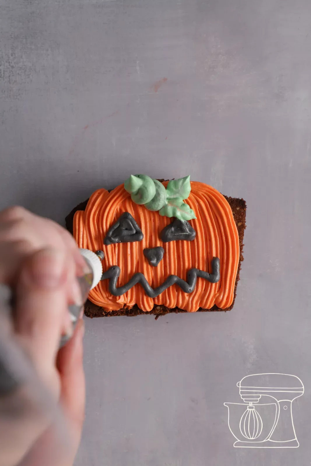 Torta a forma di zucca con occhi triangolari e bocca a zigzag