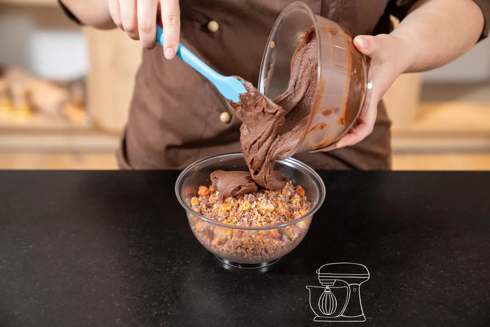 Adding the chocolate ganache to the cake crumbs