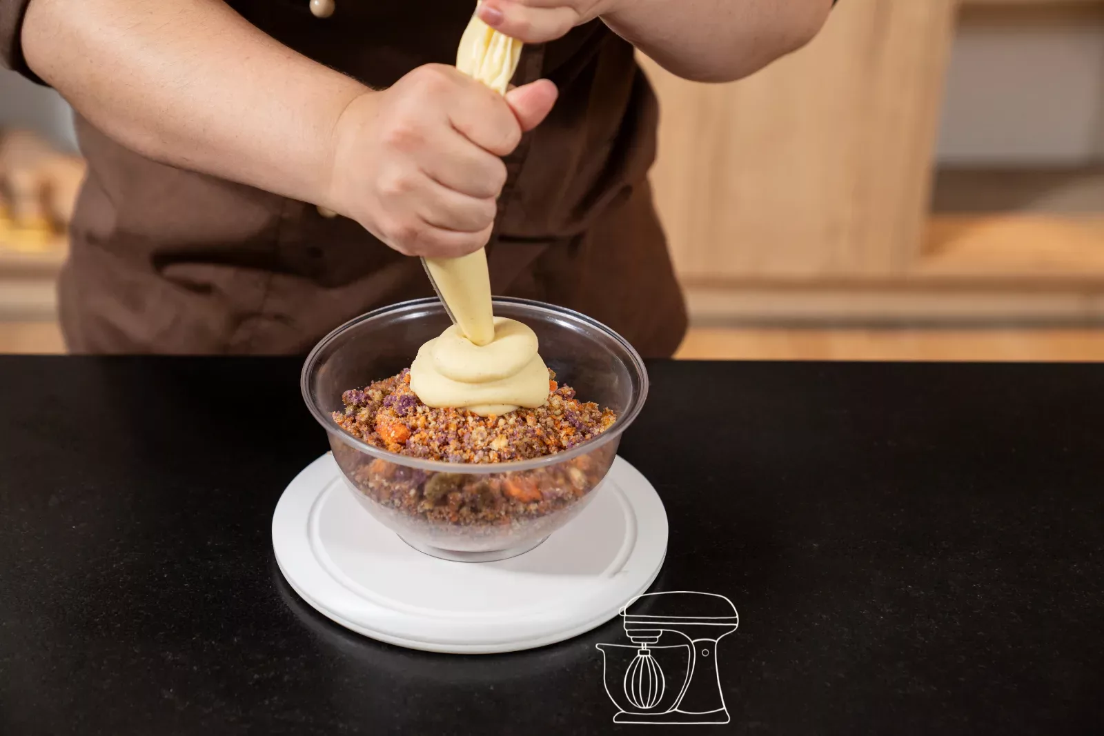 Piping the vanilla ganache onto the crumbs