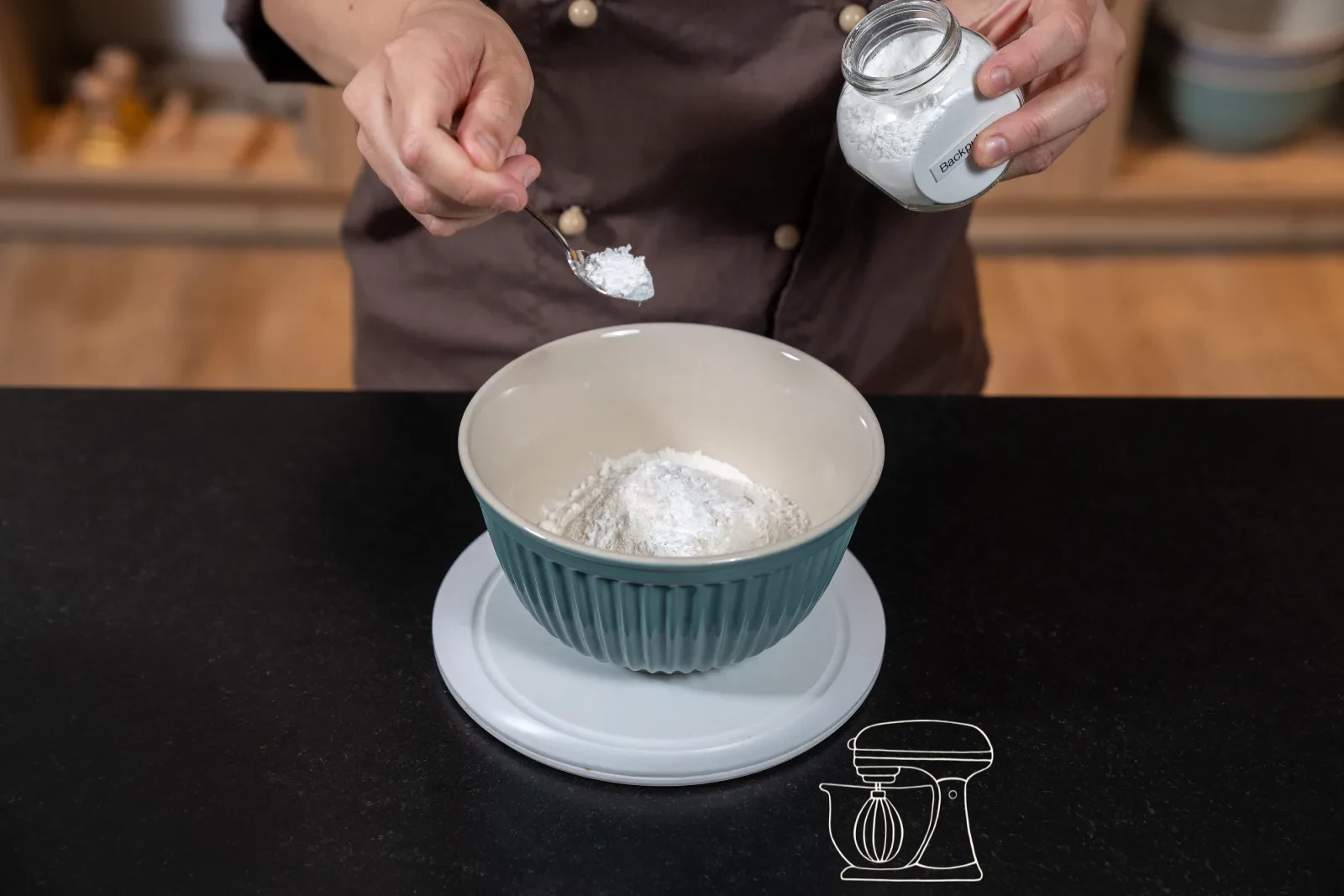 Sieved flour mixture being folded into the batter with the dough scraper
