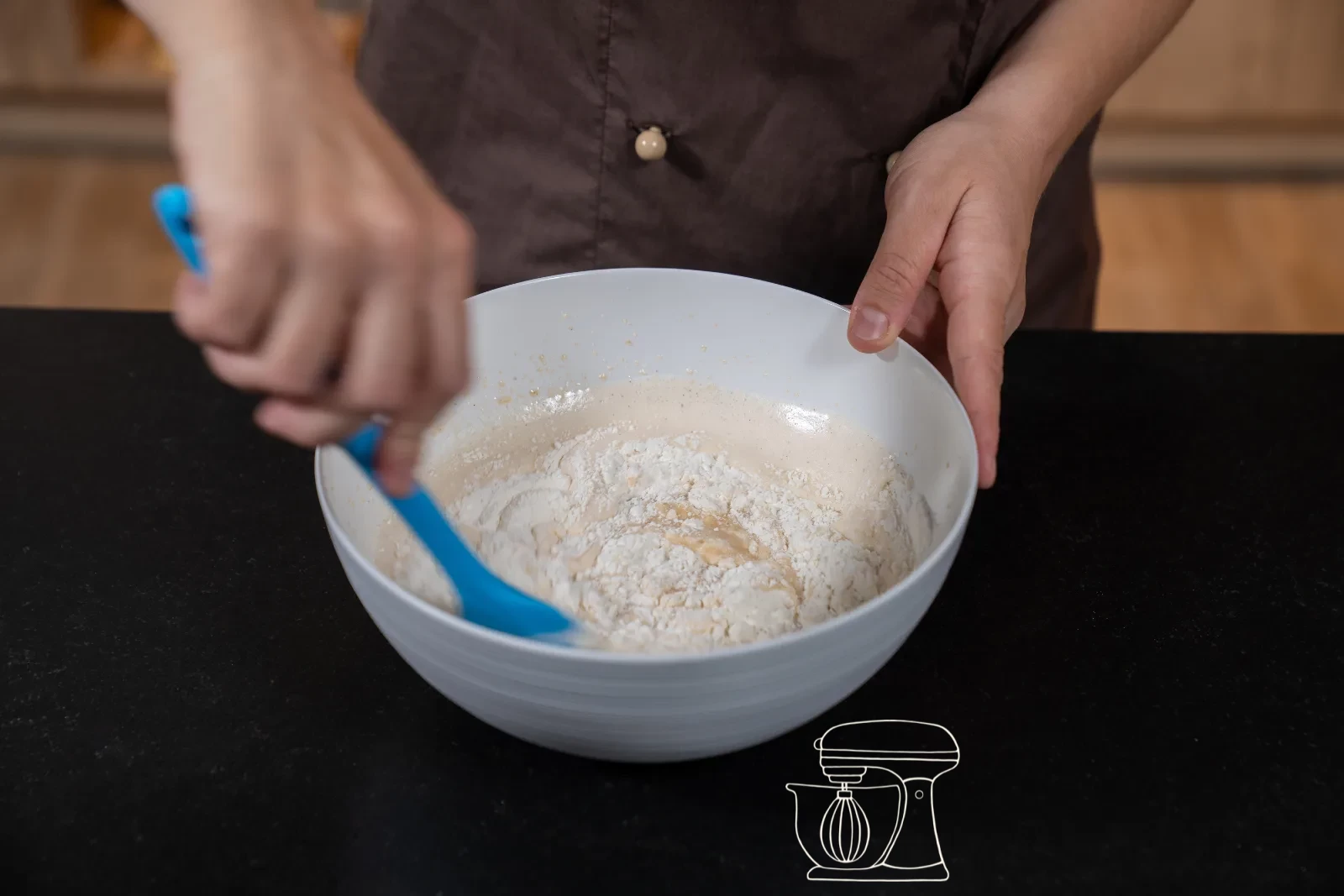 Sieved flour mixture being folded into the batter with the dough scraper