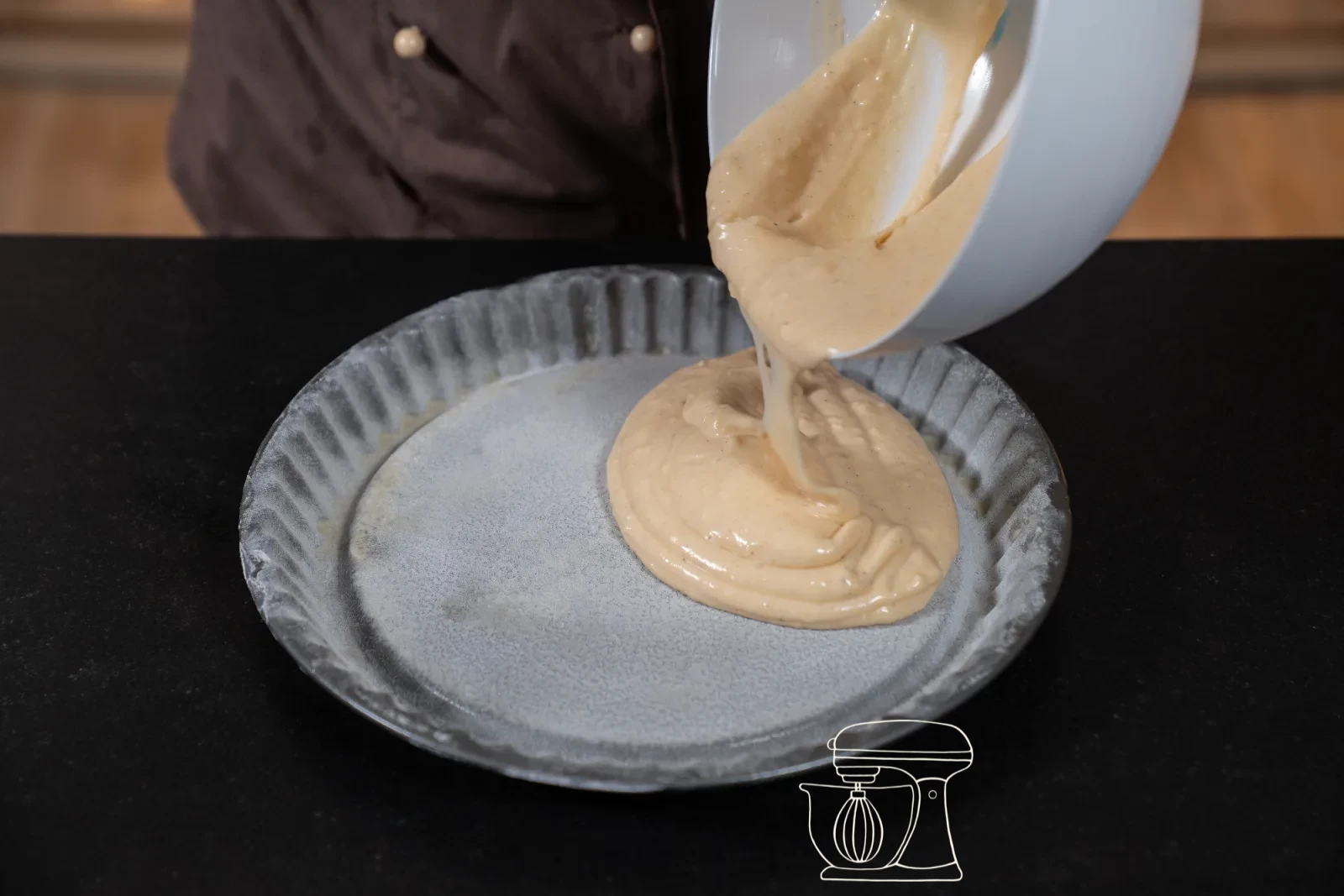 Golden-baked sponge cake base being turned out of the tin, hollow facing up