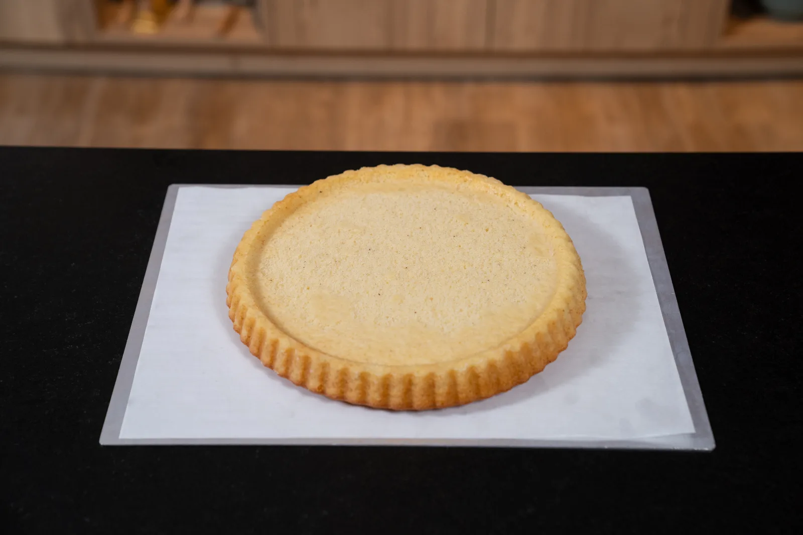 Golden-baked sponge cake base being turned out of the tin, hollow facing up