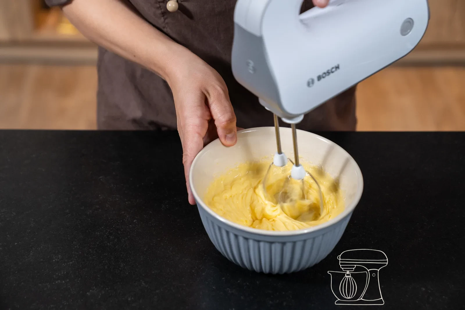 Smooth custard cream being whipped in a bowl with the hand mixer