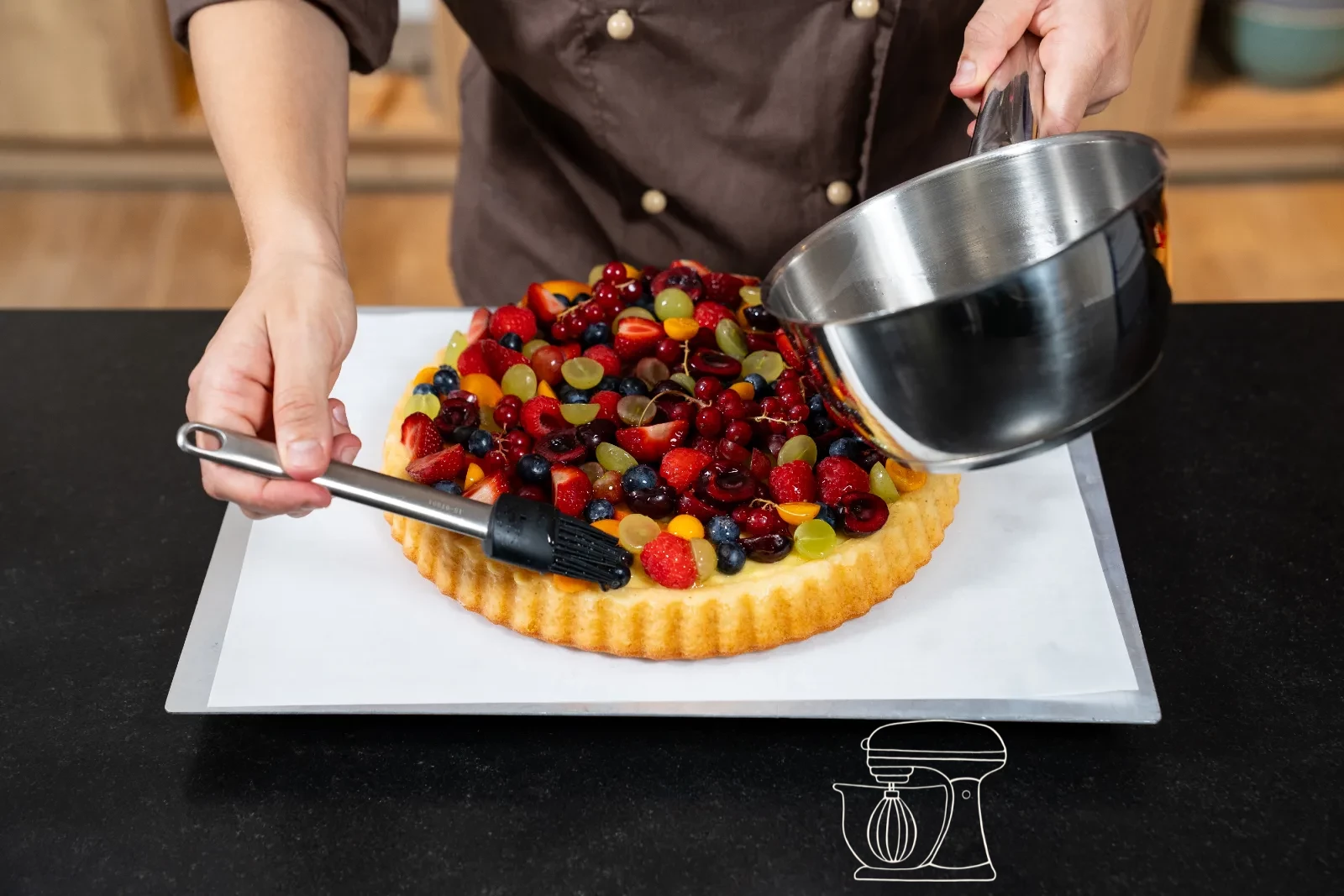 Fruit on the fruit cake being brushed glossy with warm cake glaze