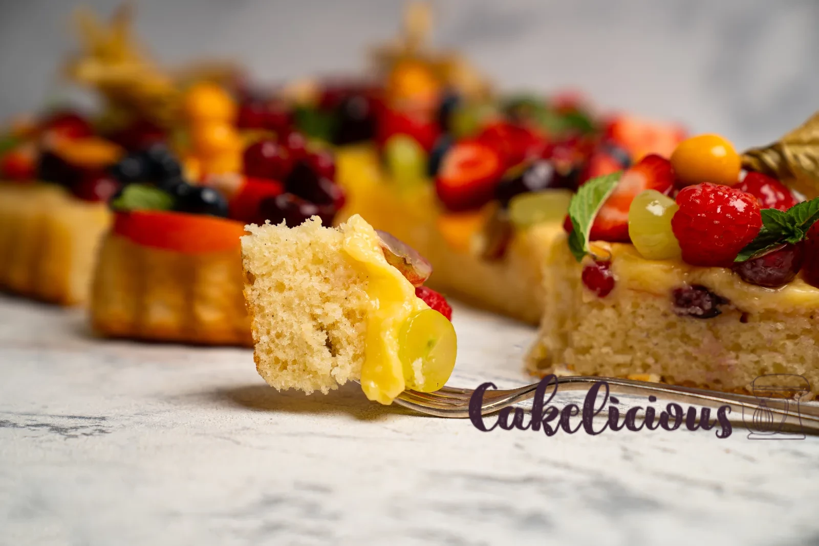 Sponge cake base with custard cream and glazed summer fruits on a cake plate