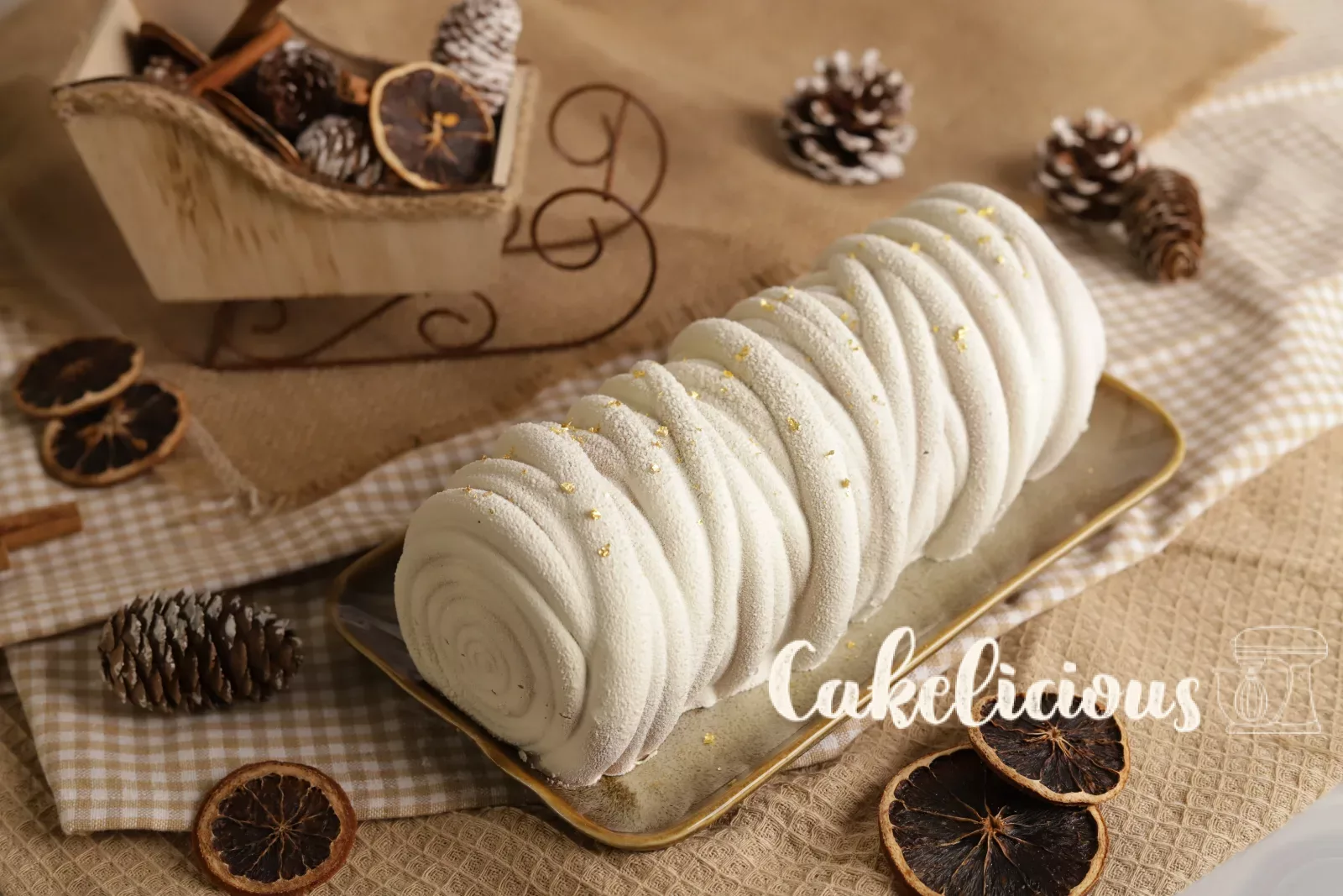Bûche all'arancia e pan di zenzero al cioccolato con stecche di cannella e pigne