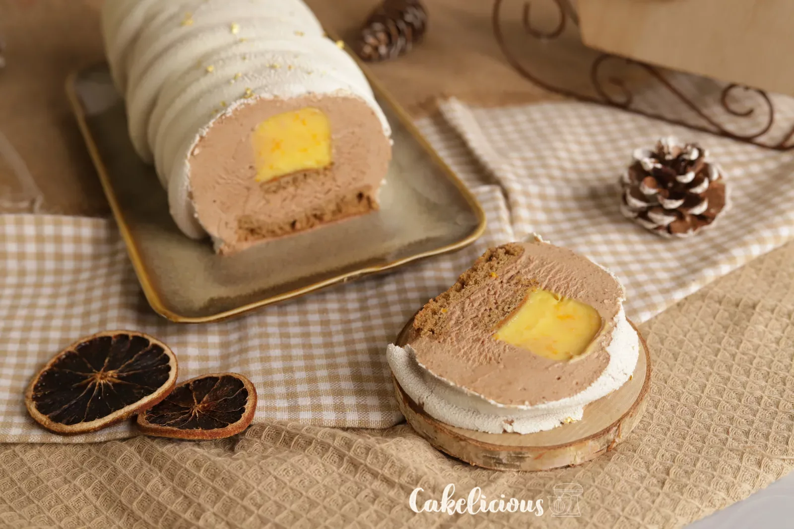 Fetta di bûche con crema all'arancia, mousse al pan di zenzero e pan di Spagna Madeleine