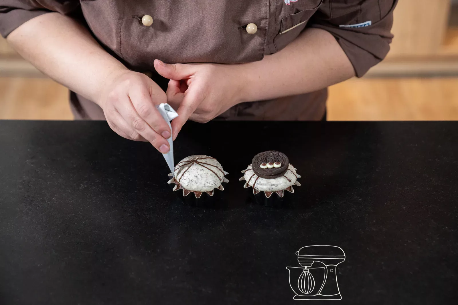 Zuerst die Beine · salt1: Spinnenbeine werden mit dunkler Kuchenglasur auf das Frosting gespritzt