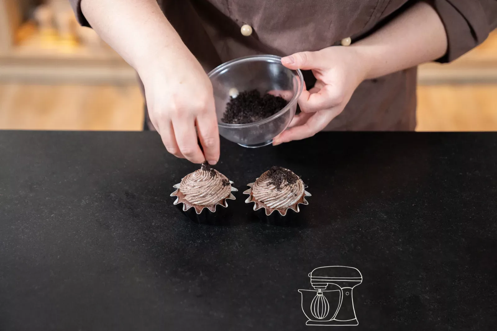 Oreo-Brösel werden über das braune Frosting gestreut