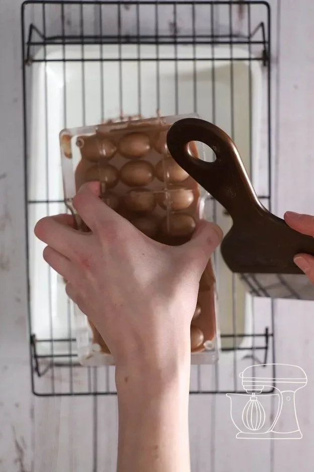 Tapoter le moule avec le manche de la spatule