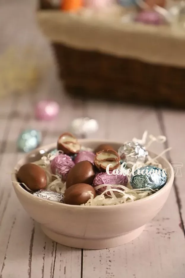 Bonbons au chocolat dans une coupe devant un panier de Pâques