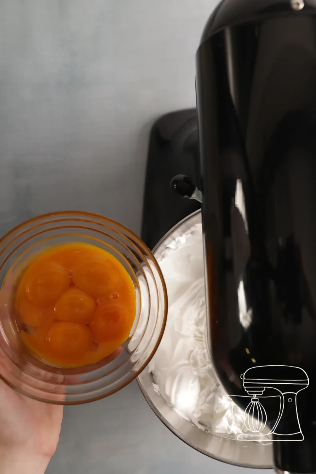 Egg yolks being beaten in one at a time