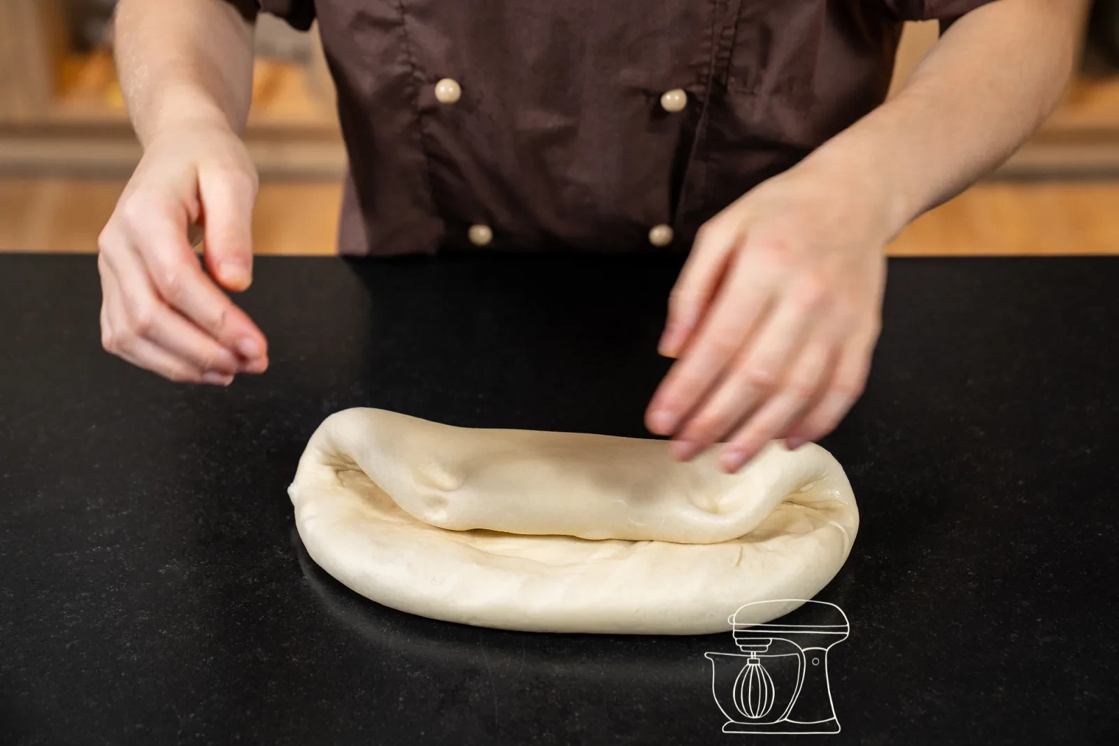 The dough is pressed flat on the floured work surface