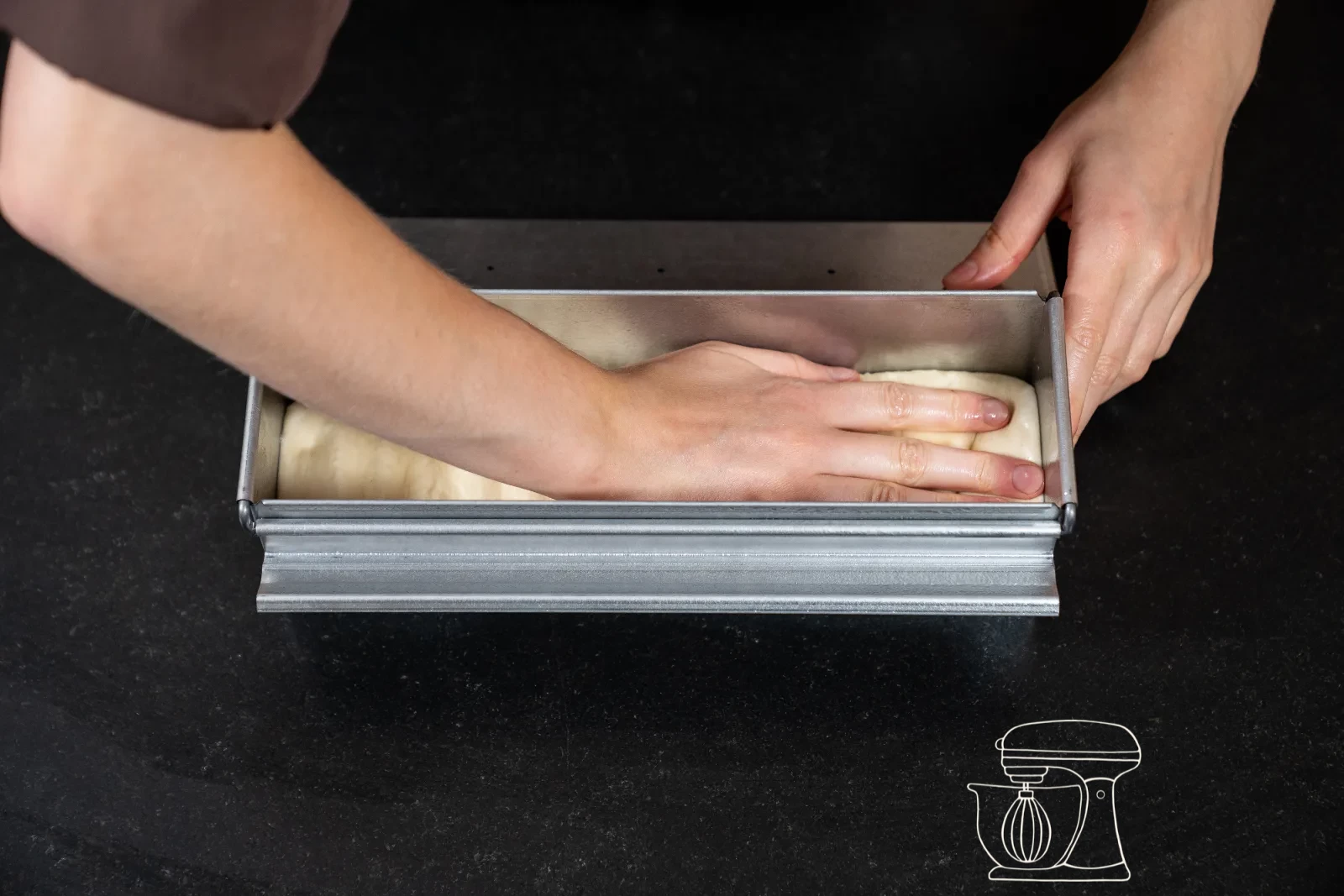 The dough is pressed firmly into all corners with the hands
