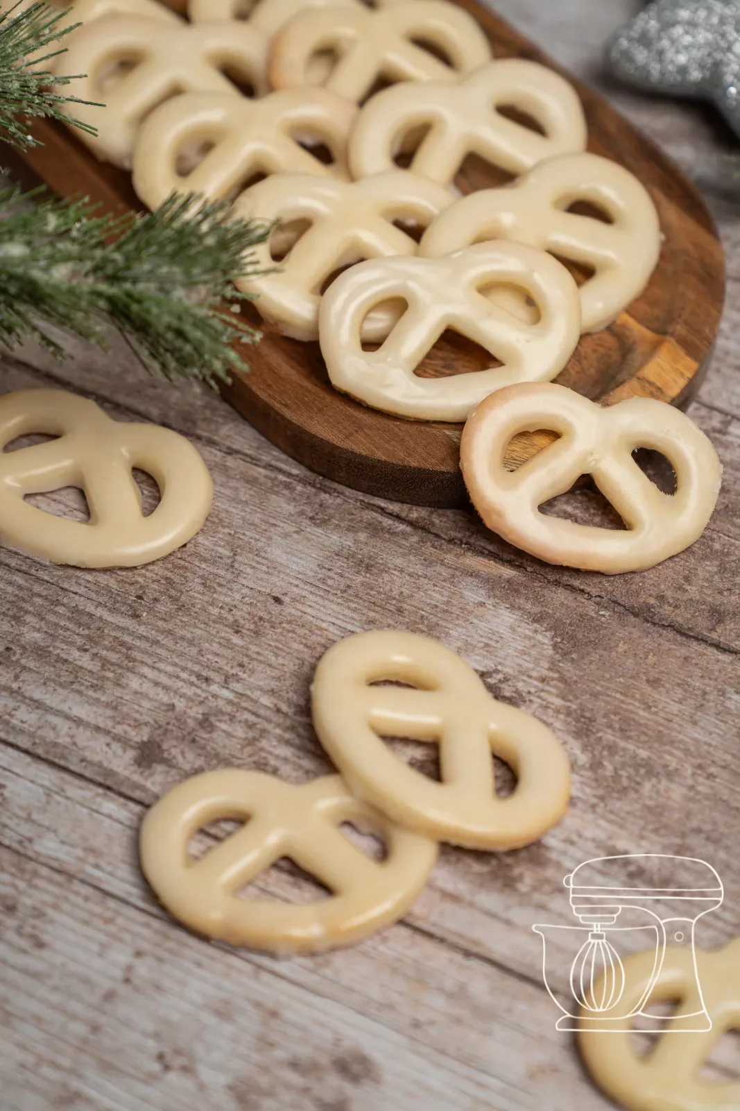 Bretzels à la vanille sur une planche en bois avec des branches de sapin