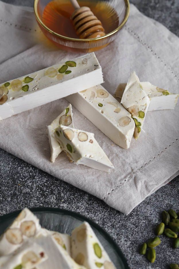 Homemade white Nougat%3A%20Ingredients%20for%20Nougat%20with%20Honey%2C%20Almonds%20and%20Pistachios pieces with hazelnuts and Pistachios