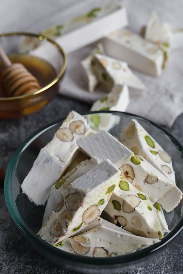 Homemade white Nougat%3A%20Ingredients%20for%20Nougat%20with%20Honey%2C%20Almonds%20and%20Pistachios pieces with hazelnuts and Pistachios