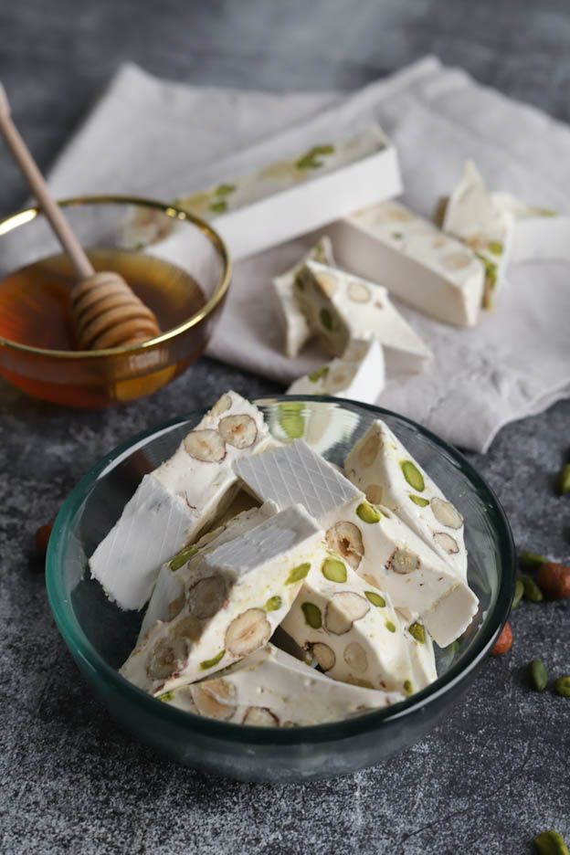 Homemade white Nougat%3A%20Ingredients%20for%20Nougat%20with%20Honey%2C%20Almonds%20and%20Pistachios pieces with hazelnuts and Pistachios
